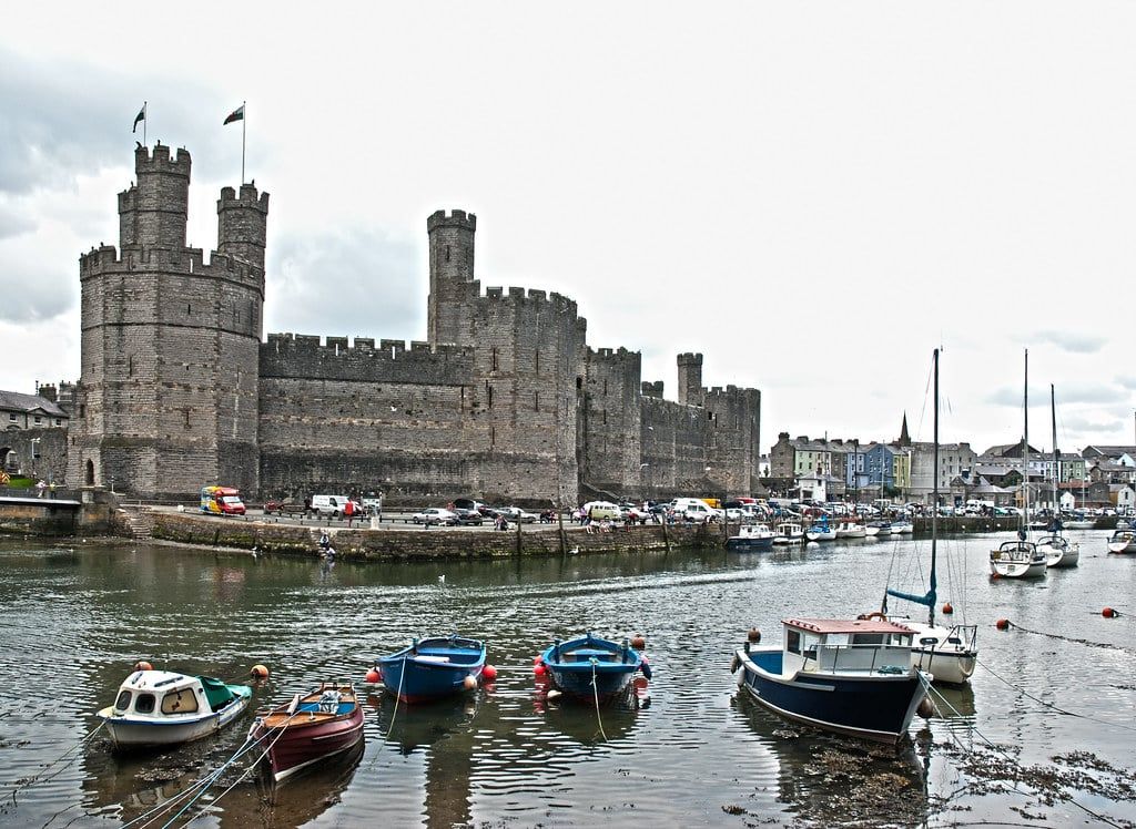 Le château de Caernarfon domine des bateaux amarrés dans le port près de Snowdonia.