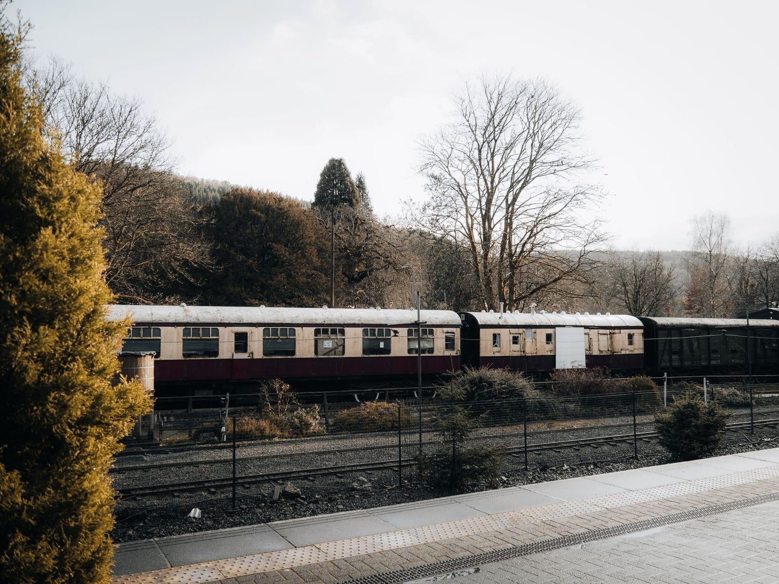 Een passagierstrein staat op de sporen naast het perron van het station van Betws-y-Coed in Snowdonia.