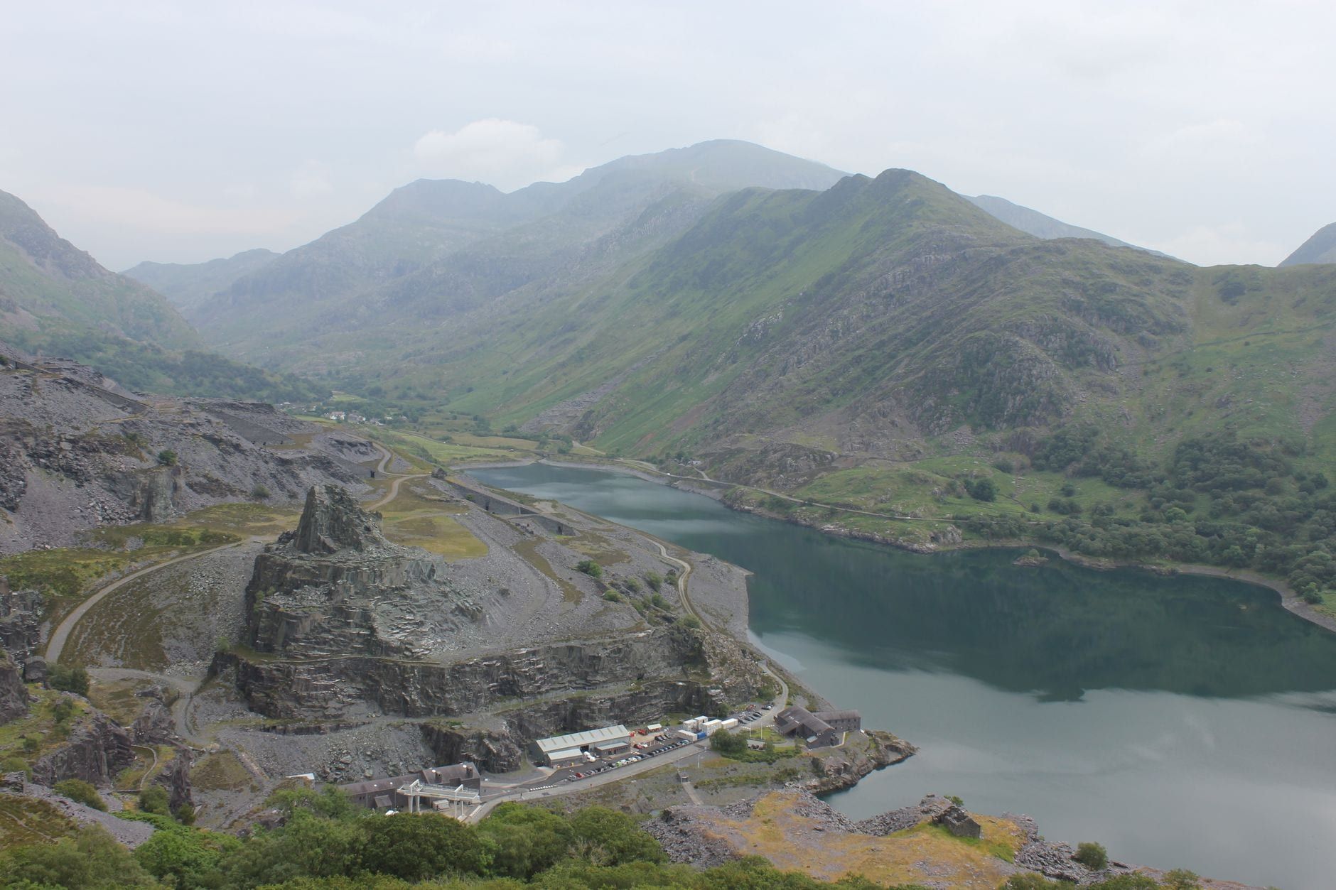 Vogelperspektive auf den Llyn Peris und historische Schiefersteinbrüche vor den schroffen Berggipfeln von Snowdonia.
