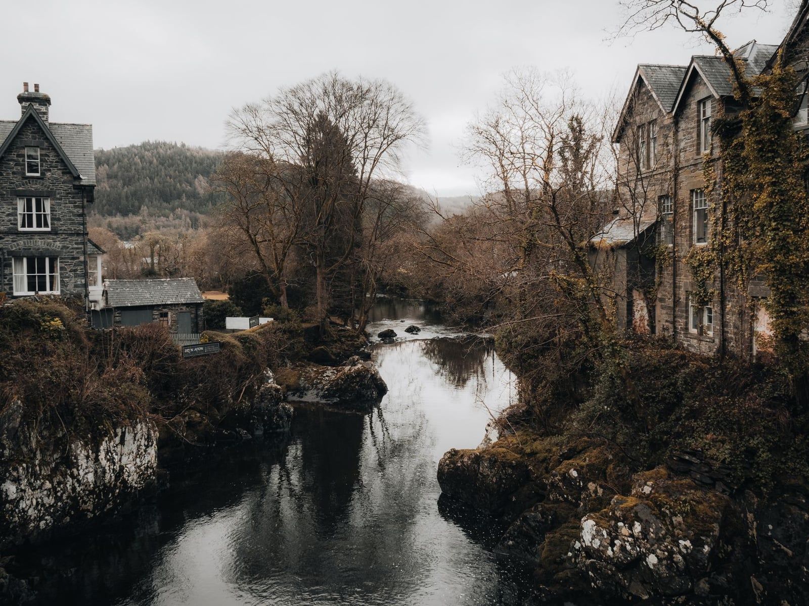 Stenen gebouwen langs de rivier in het dorp Betws-y-Coed, Snowdonia.