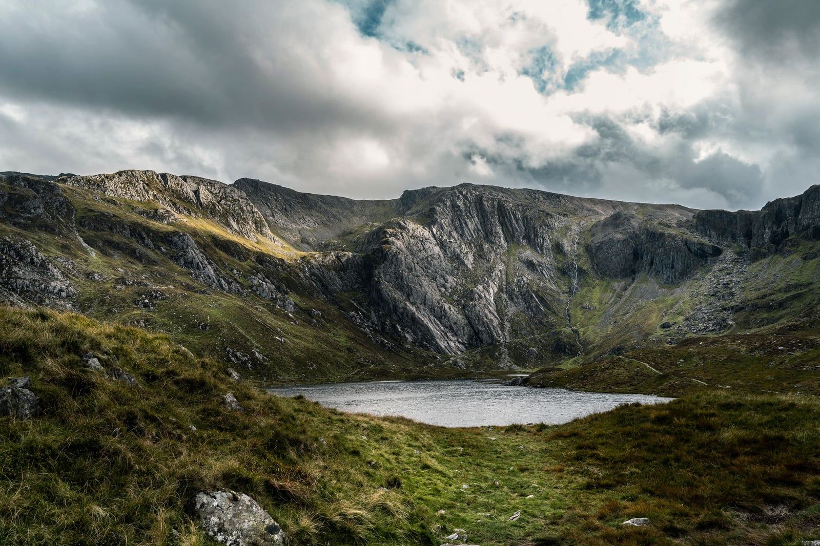 Rugged cliffs rise dramatically above the waters of Llyn Cau at Cadair Idris in Snowdonia.